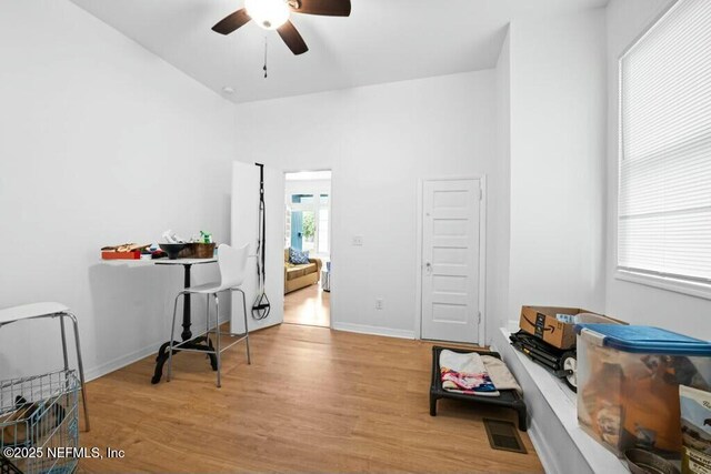 office space with visible vents, ceiling fan, wood finished floors, and baseboards