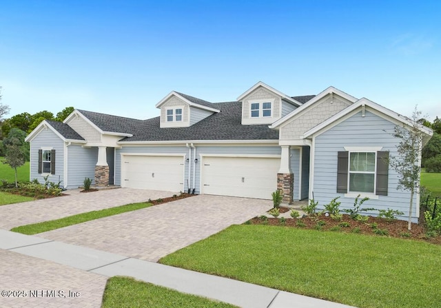 317 Dogleg Run, Saint Johns, FL 32259 - craftsman-style home featuring a front lawn, a garage, driveway, roof with shingles, and stone siding