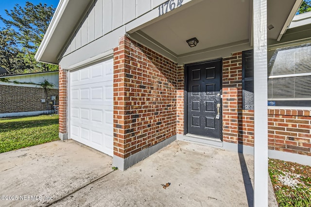 11764 Raven Dr W, Jacksonville, FL 32218 - view of exterior entry with a garage, brick siding, driveway, and board and batten siding