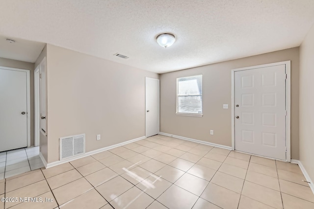 11764 Raven Dr W, Jacksonville, FL 32218 - empty room featuring light tile patterned floors, visible vents, baseboards, and a textured ceiling