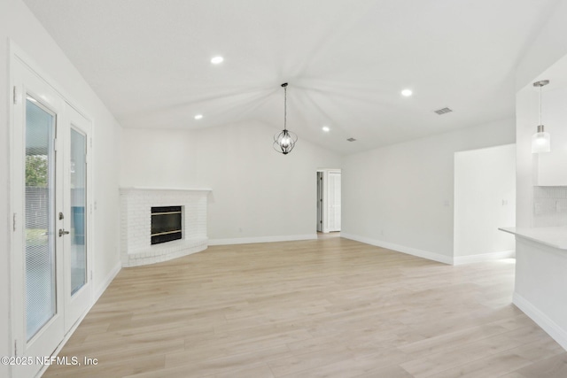 unfurnished living room with visible vents, a fireplace, baseboards, lofted ceiling, and recessed lighting