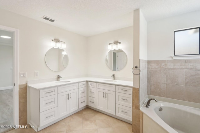 full bath with double vanity, visible vents, a sink, and tile patterned flooring