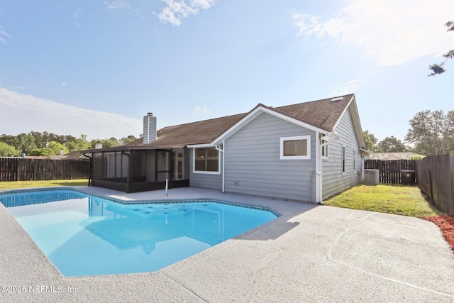 view of swimming pool featuring a fenced in pool, a fenced backyard, a sunroom, and a patio area