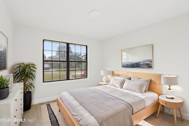 bedroom with baseboards and light wood finished floors