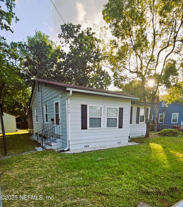 4916 Dundee Rd, Jacksonville, FL 32210 - view of front of house with entry steps, a front lawn, and crawl space