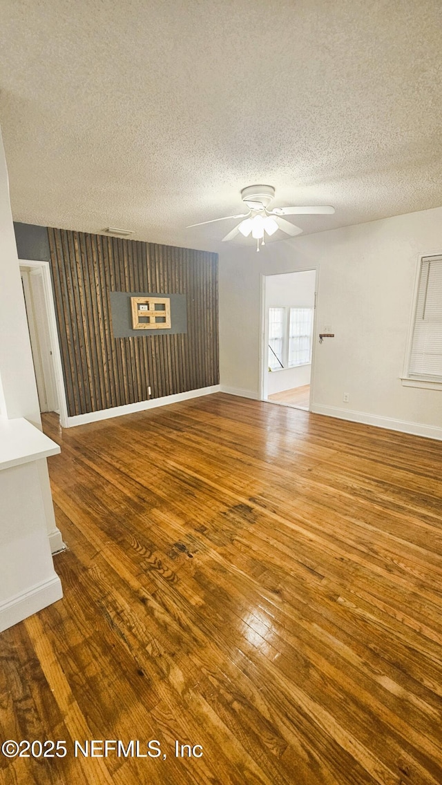 4916 Dundee Rd, Jacksonville, FL 32210 - unfurnished living room featuring hardwood / wood-style floors, ceiling fan, baseboards, and a textured ceiling