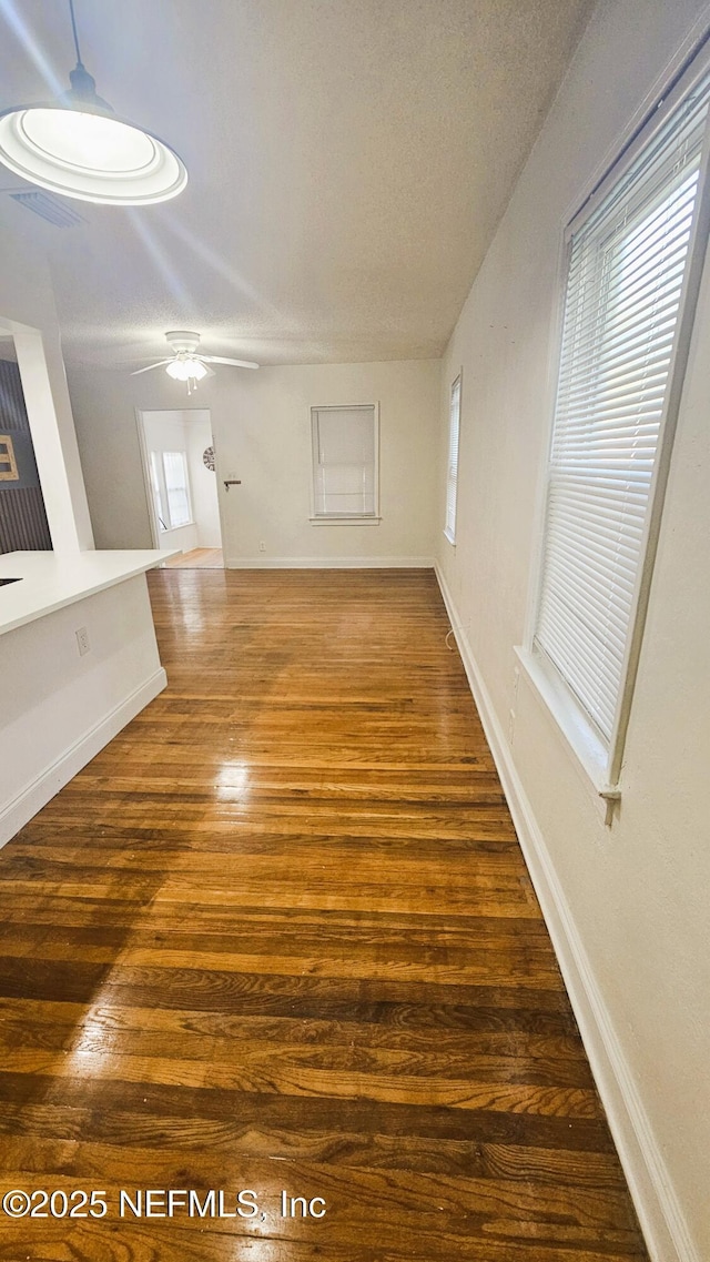 4916 Dundee Rd, Jacksonville, FL 32210 - unfurnished living room with baseboards, a textured ceiling, visible vents, ceiling fan, and wood finished floors