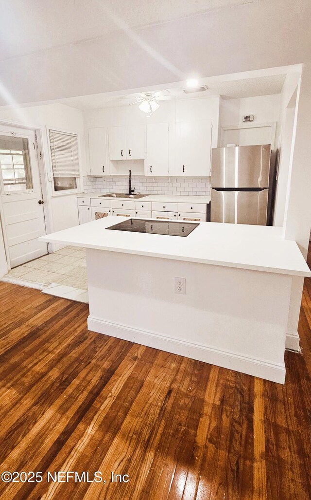 4916 Dundee Rd, Jacksonville, FL 32210 - kitchen featuring tasteful backsplash, white cabinetry, freestanding refrigerator, and black electric cooktop