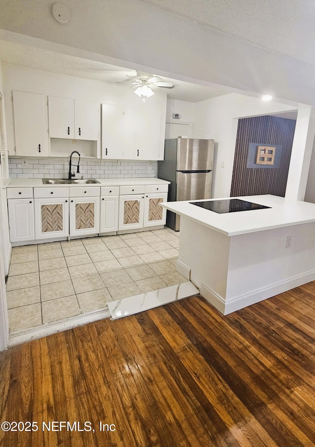 4916 Dundee Rd, Jacksonville, FL 32210 - kitchen with ceiling fan, freestanding refrigerator, a sink, light wood finished floors, and black electric cooktop