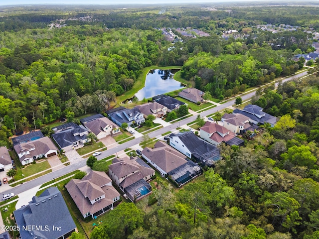 drone / aerial view featuring a water view, a residential view, and a forest view
