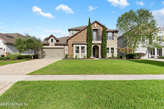 view of front of home with stone siding, stucco siding, a front yard, a balcony, and driveway