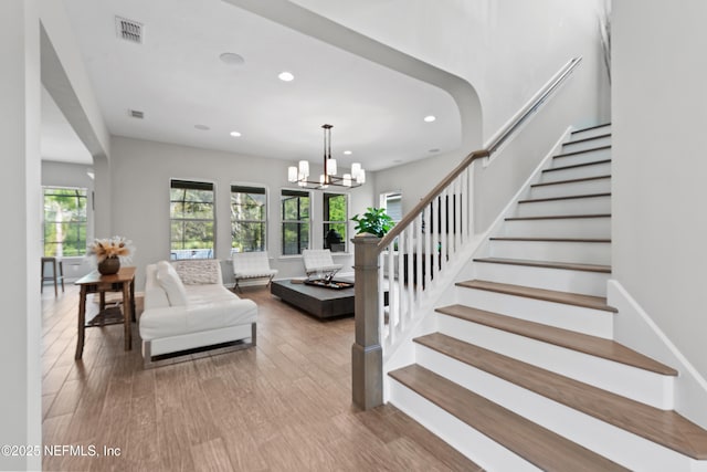 staircase with recessed lighting, wood finished floors, a chandelier, and visible vents
