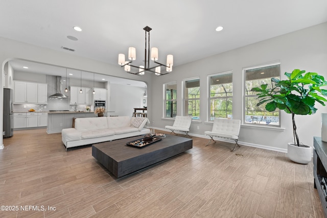 living area with a chandelier, recessed lighting, baseboards, light wood-type flooring, and visible vents