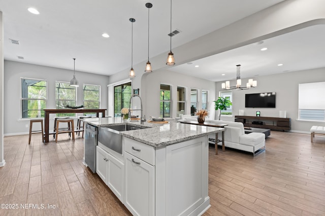 kitchen with visible vents, stainless steel dishwasher, light wood-style flooring, a sink, and white cabinetry