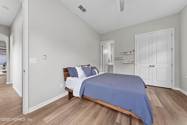 bedroom with visible vents, a closet, wood finished floors, baseboards, and a ceiling fan