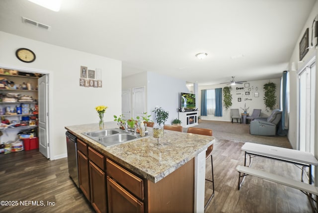 kitchen with ceiling fan, stainless steel dishwasher, dark wood-type flooring, visible vents, and a sink