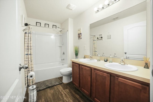 full bath featuring wood finished floors, visible vents, a sink, and double vanity