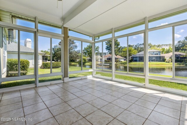 unfurnished sunroom with a water view and a residential view