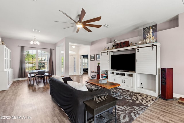 11975 Smith Pointe Ct, Jacksonville, FL 32218 - living room with ceiling fan with notable chandelier, baseboards, and wood finished floors