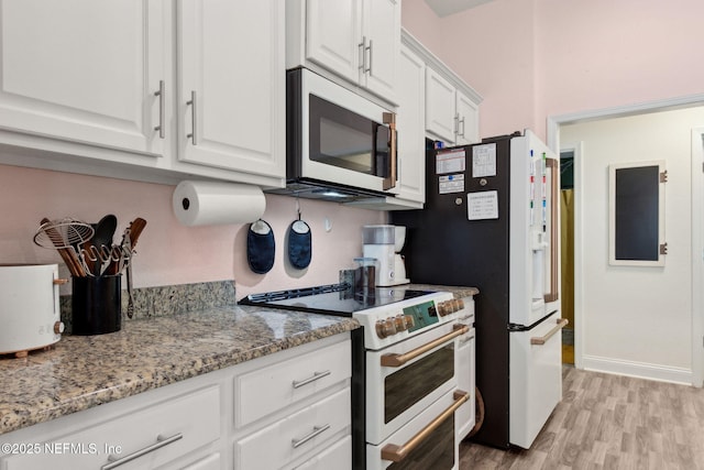 11975 Smith Pointe Ct, Jacksonville, FL 32218 - kitchen with white cabinets, baseboards, light wood-type flooring, white appliances, and light stone counters