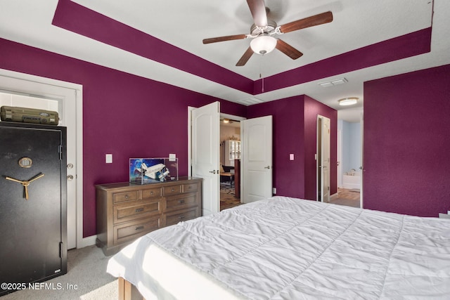 11975 Smith Pointe Ct, Jacksonville, FL 32218 - bedroom with visible vents, baseboards, a ceiling fan, a tray ceiling, and connected bathroom