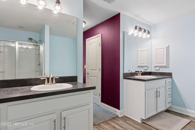 11975 Smith Pointe Ct, Jacksonville, FL 32218 - bathroom featuring a shower stall, wood finished floors, two vanities, and a sink