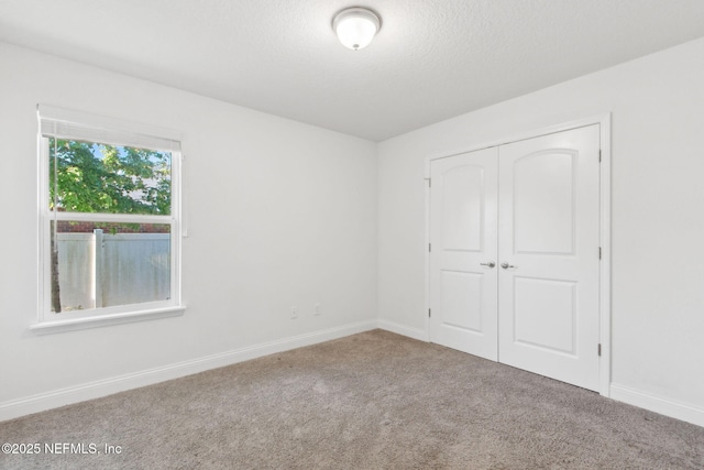 11975 Smith Pointe Ct, Jacksonville, FL 32218 - unfurnished bedroom with carpet, a closet, baseboards, and a textured ceiling