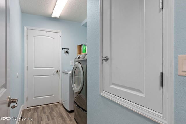 11975 Smith Pointe Ct, Jacksonville, FL 32218 - clothes washing area featuring washing machine and dryer, laundry area, a textured ceiling, and wood finished floors
