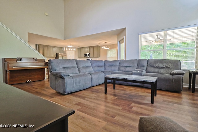 3038 Majestic Oaks Ln, Green Cove Springs, FL 32043 - living room featuring an inviting chandelier, a high ceiling, and wood finished floors