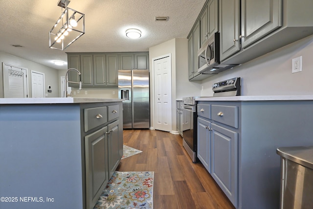 3038 Majestic Oaks Ln, Green Cove Springs, FL 32043 - kitchen featuring stainless steel appliances, gray cabinetry, visible vents, and dark wood finished floors