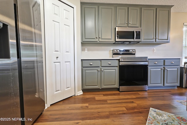 3038 Majestic Oaks Ln, Green Cove Springs, FL 32043 - kitchen with gray cabinets, light countertops, a textured ceiling, dark wood-type flooring, and appliances with stainless steel finishes