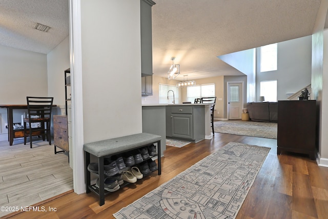 3038 Majestic Oaks Ln, Green Cove Springs, FL 32043 - living room with a chandelier, visible vents, a textured ceiling, and wood finished floors