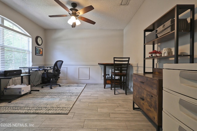 3038 Majestic Oaks Ln, Green Cove Springs, FL 32043 - office space with visible vents, ceiling fan, a textured ceiling, wood tiled floor, and a wainscoted wall