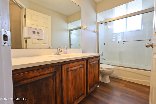 3038 Majestic Oaks Ln, Green Cove Springs, FL 32043 - bathroom with toilet, wood finished floors, vanity, and combined bath / shower with glass door