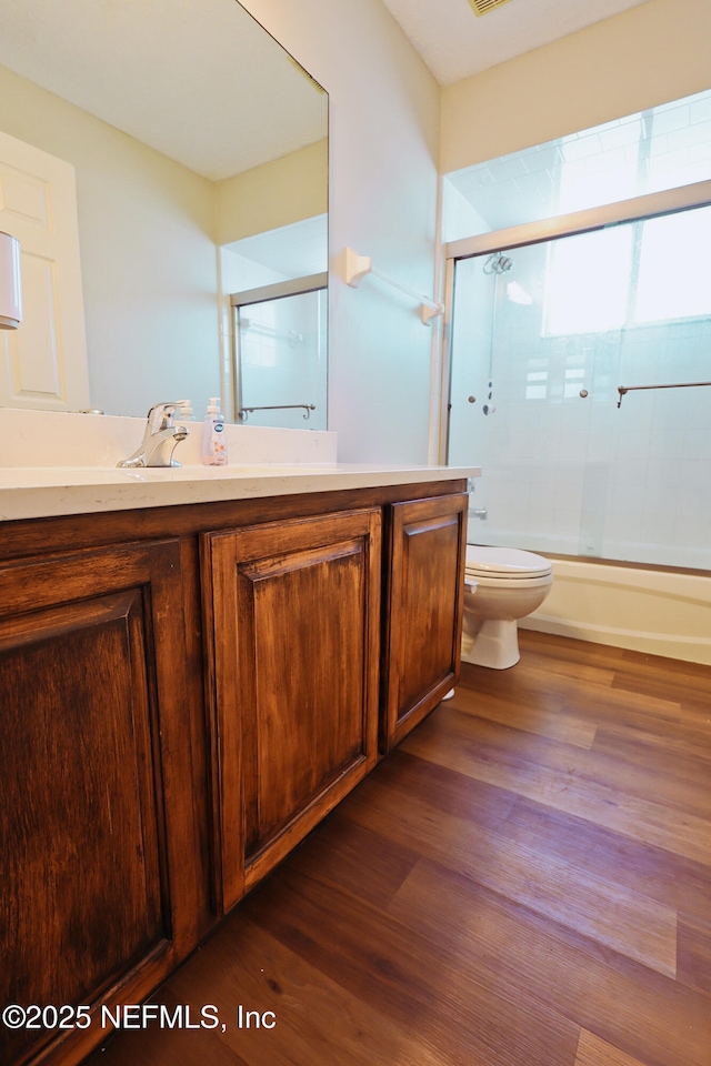 3038 Majestic Oaks Ln, Green Cove Springs, FL 32043 - bathroom featuring toilet, enclosed tub / shower combo, vanity, and wood finished floors