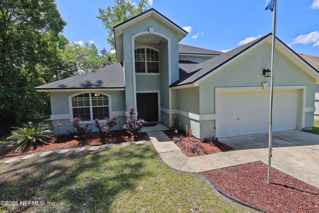 3038 Majestic Oaks Ln, Green Cove Springs, FL 32043 - view of front of house featuring roof with shingles, an attached garage, driveway, and stucco siding