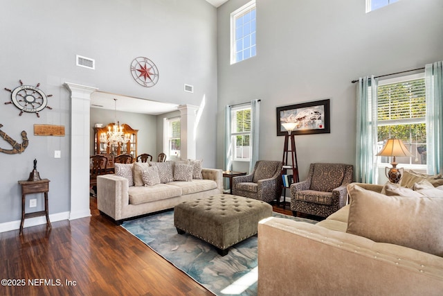 11725 Paddock Gates Dr, Jacksonville, FL 32223 - living room with decorative columns, dark wood-type flooring, a chandelier, a towering ceiling, and baseboards