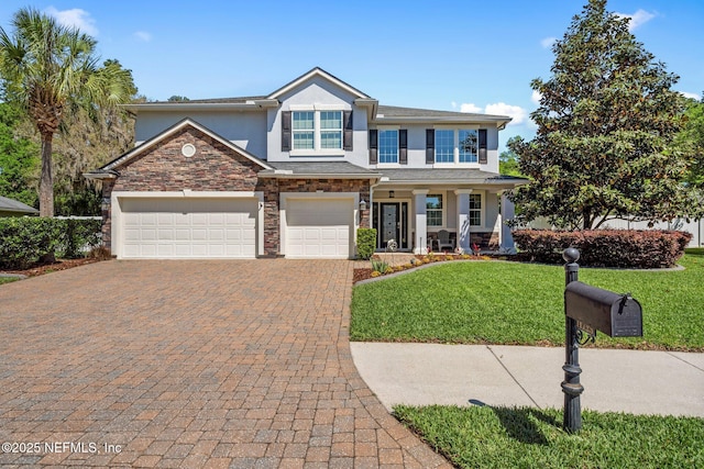 11725 Paddock Gates Dr, Jacksonville, FL 32223 - view of front facade with stucco siding, decorative driveway, stone siding, a front lawn, and a porch