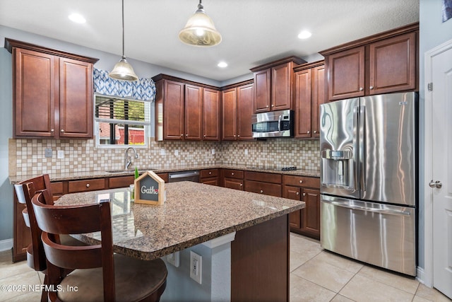 11725 Paddock Gates Dr, Jacksonville, FL 32223 - kitchen featuring appliances with stainless steel finishes, a sink, tasteful backsplash, decorative light fixtures, and a breakfast bar area