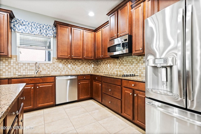 11725 Paddock Gates Dr, Jacksonville, FL 32223 - kitchen featuring appliances with stainless steel finishes, a sink, light tile patterned floors, and decorative backsplash