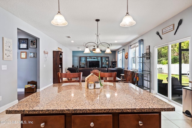 11725 Paddock Gates Dr, Jacksonville, FL 32223 - kitchen featuring light stone counters, pendant lighting, light tile patterned flooring, and baseboards