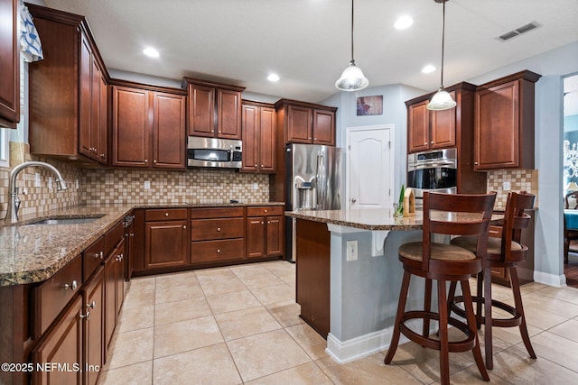 11725 Paddock Gates Dr, Jacksonville, FL 32223 - kitchen with appliances with stainless steel finishes, a sink, dark stone counters, tasteful backsplash, and a kitchen bar