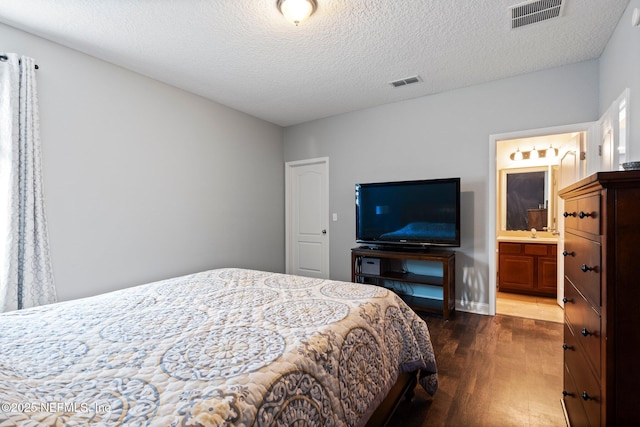11725 Paddock Gates Dr, Jacksonville, FL 32223 - bedroom featuring dark wood-type flooring, a textured ceiling, and ensuite bath