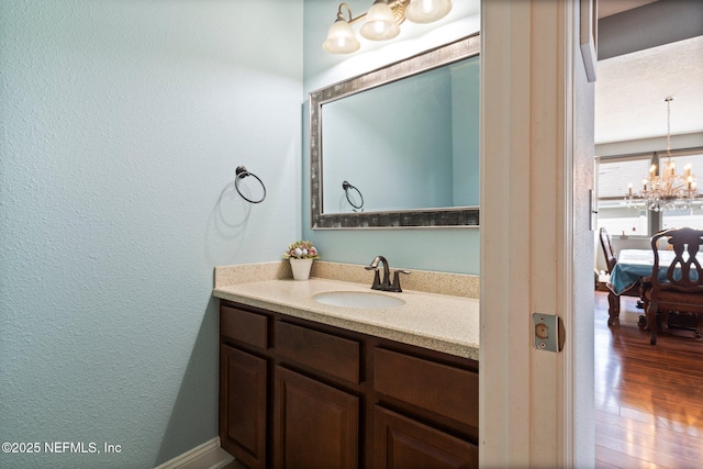 11725 Paddock Gates Dr, Jacksonville, FL 32223 - bathroom featuring vanity, a textured wall, a chandelier, and wood finished floors