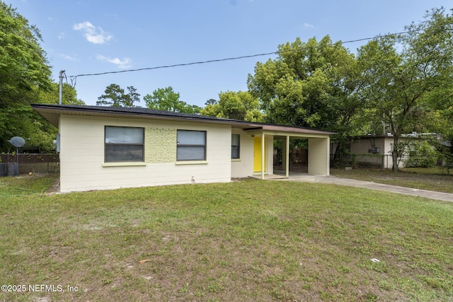 ranch-style home featuring a front lawn, fence, driveway, and an attached carport