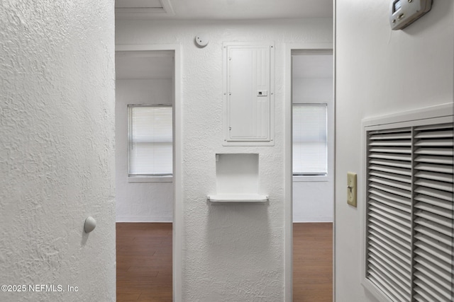 room details with electric panel, a textured wall, and a heating unit