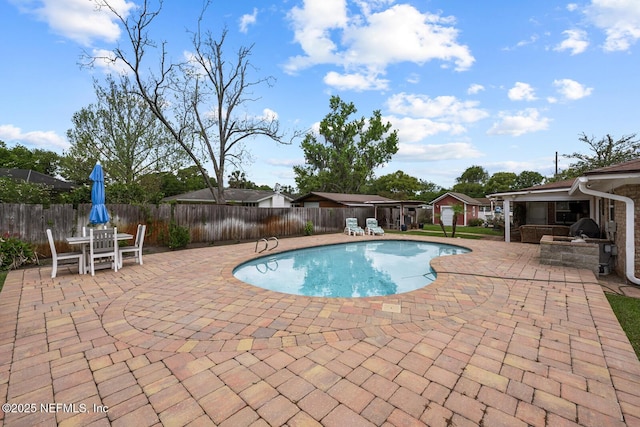 706 Montego Rd E, Jacksonville, FL 32216 - view of swimming pool with exterior kitchen, a fenced backyard, outdoor dining space, a patio, and a fenced in pool