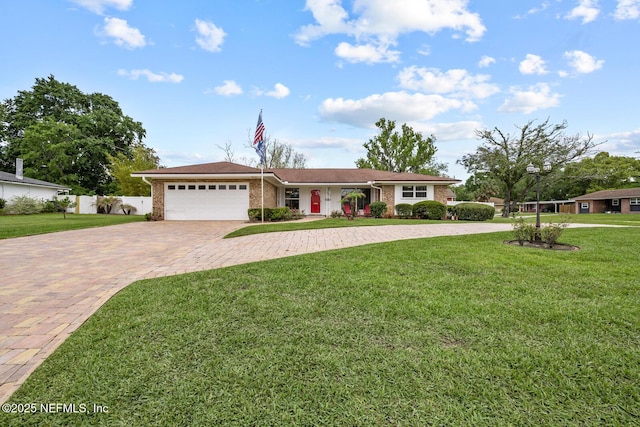 706 Montego Rd E, Jacksonville, FL 32216 - single story home featuring decorative driveway, an attached garage, a front yard, brick siding, and fence