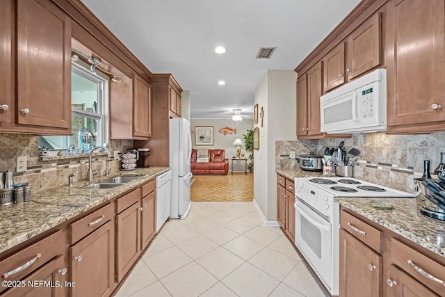 706 Montego Rd E, Jacksonville, FL 32216 - kitchen featuring visible vents, light tile patterned floors, a sink, white appliances, and decorative backsplash