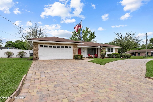 706 Montego Rd E, Jacksonville, FL 32216 - ranch-style house featuring a front yard, fence, a garage, and decorative driveway